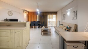 Ein modernes Wohnzimmer mit einer Couch, einem Couchtisch und einem Essbereich mit Stühlen und einem Tisch.