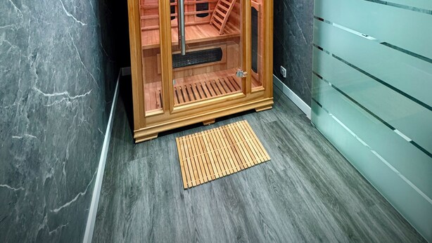 A sauna with a wooden interior, marble walls, and a pink ceiling. - Suite 1 Private Jacuzzi Spa Hot Tub & Sauna (Sheffield)