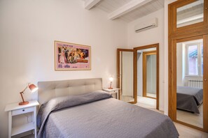 A bedroom with a bed, bedside tables, a poster on the wall, and a mirror. - 2 Bedrooms & 2 Bathrooms Monti (Roma)