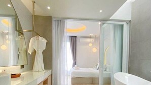 Ein modernes Badezimmer mit einer großen Badewanne, einem Waschtisch mit Spiegel und einer Duschkabine.
