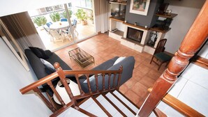 Un salon moderne avec un escalier, un coin repas avec une table ronde et des chaises, et une cheminée.