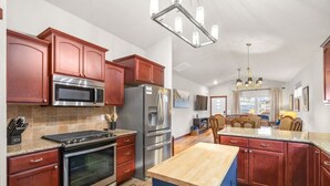 Una cucina moderna con elettrodomestici in acciaio inossidabile, mobili in legno e un'isola centrale.