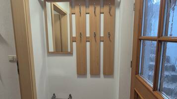 Un baño con piso de baldosas, un mueble de tocador de madera y un ventanal con vidrio esmerilado.