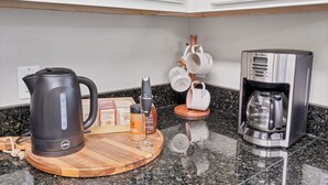 A kitchen counter with a coffee maker, a kettle, and a mug rack. - Centerpoint Getaway - The Center of FUN in East TN! (Louisville)