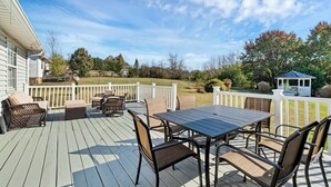 A deck with a table and chairs, a covered seating area, and a view of the surrounding landscape. - Centerpoint Getaway - The Center of FUN in East TN! (Louisville)