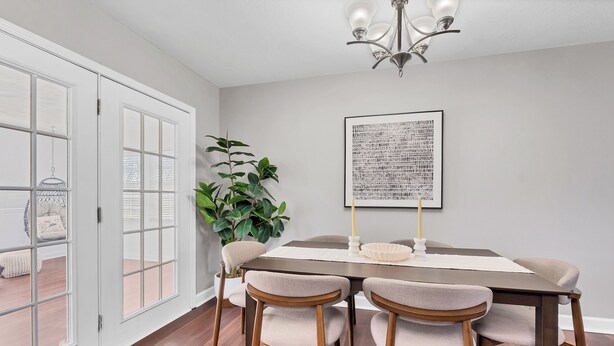 A dining area with a wooden table, four chairs, a potted plant, and a framed artwork on the wall. - Centerpoint Getaway - The Center of FUN in East TN! (Louisville)