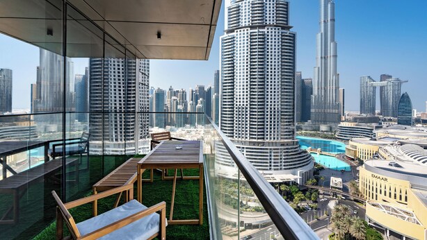 A high-rise building with a glass balcony overlooking a cityscape, featuring modern architecture and a view of the surrounding urban area. - Lux BnB Boulevard Point Burj Views (Dubai)