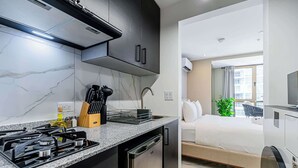 A modern kitchen with a gas stove, a built-in oven, and a stainless steel dishwasher. - w Contemporary 1BR in Vibrant Obarrio (Panama City)
