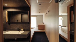 Un bany modern amb un mirall gran, un lavabo i un moble de bany de fusta.