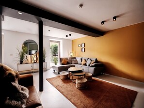 Una sala de estar moderna con un sofá, una mesa de centro y un espejo grande.