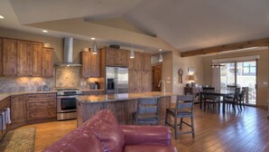 Una cocina amplia con armarios de madera, electrodomésticos de acero inoxidable y una isla central.