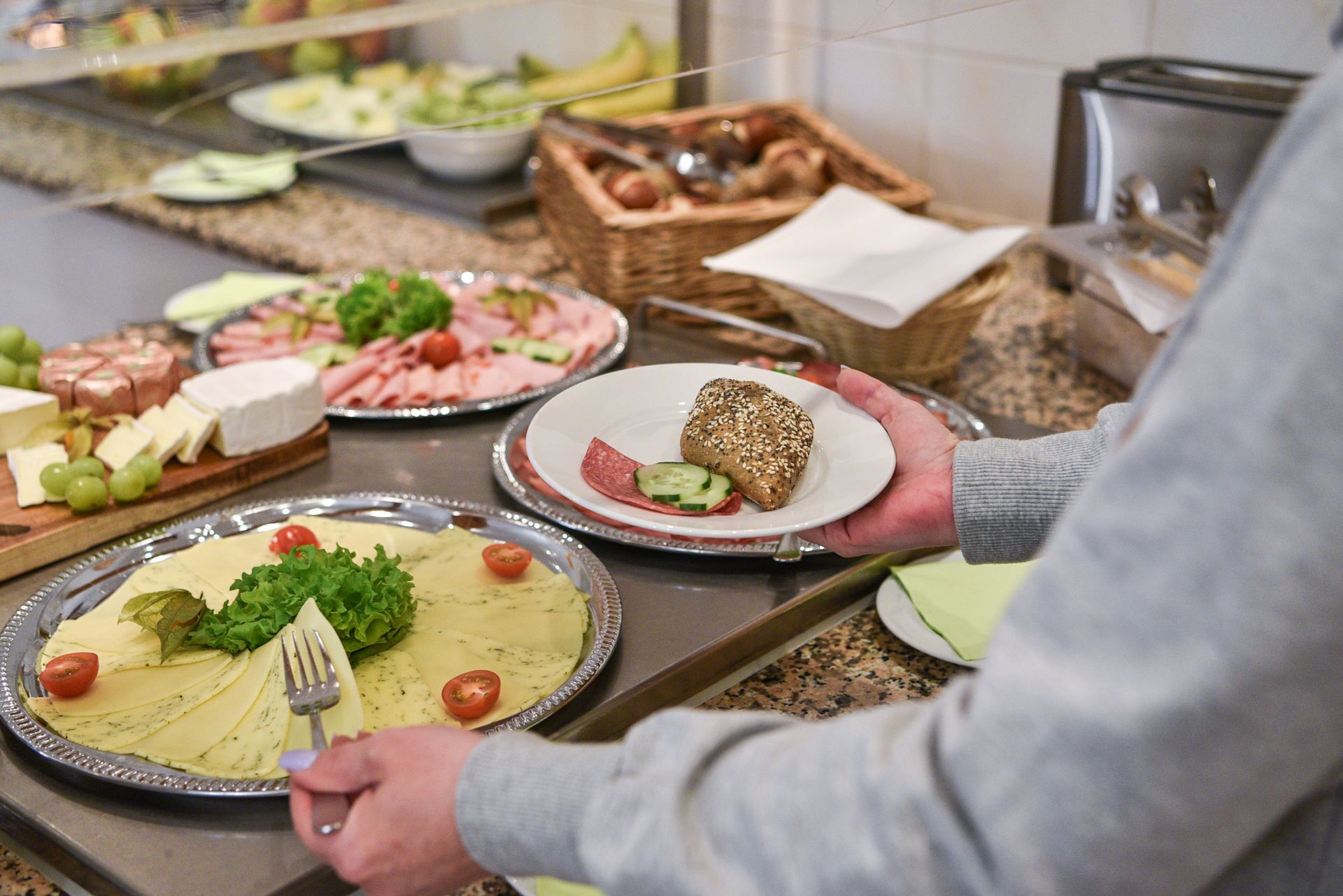 A buffet with various food items including cheese, meats, and bread.