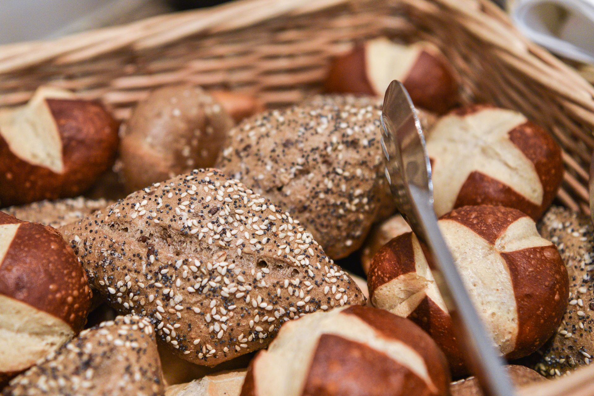 A basket of various breads, including some with seeds.