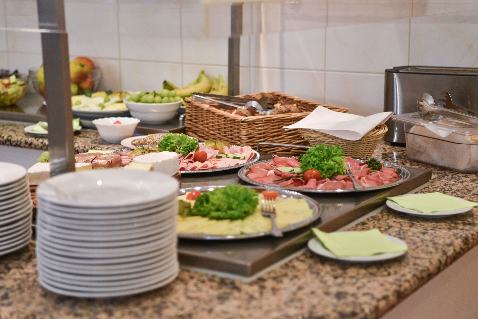 Un bufé con diversos alimentos, incluyendo carnes, quesos y ensaladas.