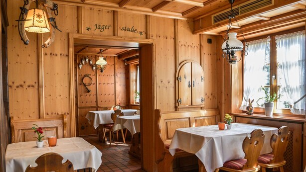 A rustic wooden interior with tables and chairs, a wooden ceiling, and a sign that reads "Jägerstuben". - Hotel Gasthof Süßer Grund (Albstadt)