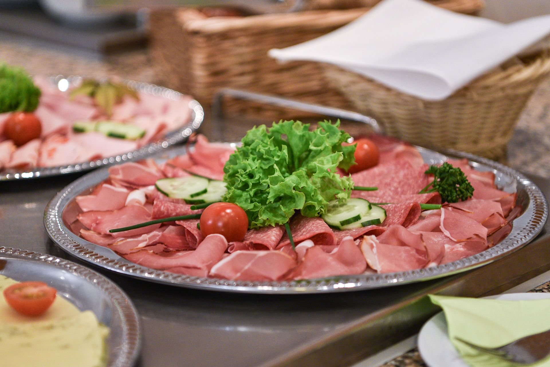A buffet table with various meats and garnishes.