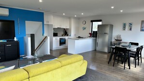 A modern kitchen with white cabinets, a central island, and a stainless steel refrigerator. - Escape to Henry's Inlet Views, a picturesque holiday rental in the charming town of Venus Bay (Venus Bay)