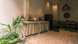 A kitchen with a central island, a ceiling fan, pendant lights, and a dining area with chairs. - Brenda Home (Nha Trang)