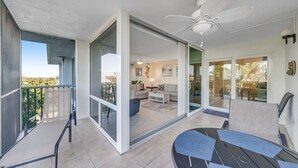 Moderni huoneisto, jossa on parveke, olohuone sohvineen ja sohvapöytineen sekä ruokailutila pöytineen ja tuoleineen.