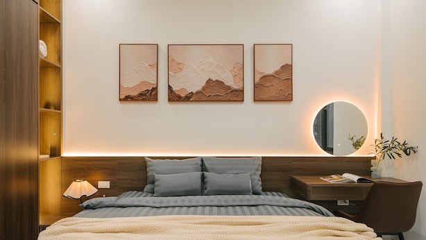 A modern bedroom with a bed, bedside table, lamp, and a wall-mounted mirror. - Tamundi Embassy - Diplomatic Quarter - West Lake Hanoi (Hanoi)
