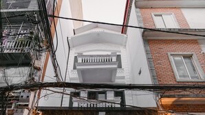 A building with a glass entrance, a motorcycle parked in front, and a sign with partially visible text. - Tamundi Embassy - Diplomatic Quarter - West Lake Hanoi (Hanoi)