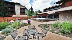Un espace extérieur aménagé avec des meubles de jardin, une piscine et un bâtiment en pierre.