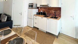 Una cucina moderna con mobili bianchi, un piano di lavoro in legno e un lampadario.