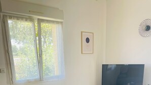 A living room with a TV, wooden furniture, and a blue carpet. - La Maison Jaune - 4 bedrooms - sleeps 7 - Quiet location (Saint-Amand-sur-Fion)