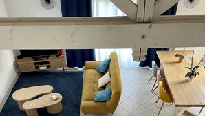 A spacious living area with a sofa, a coffee table, and a dining table with chairs. - La Maison Jaune - 4 bedrooms - sleeps 7 - Quiet location (Saint-Amand-sur-Fion)
