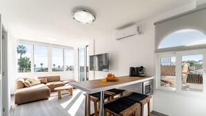 Un espacio moderno de estar con sofá, mesa de centro y barra.
