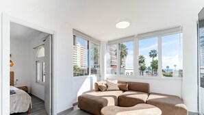 Un dormitorio moderno con un ventanal grande, un sofá y una cama.