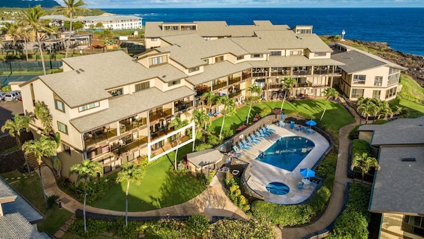 Ein Resort mit mehreren Gebäuden, einem Schwimmbad und Blick aufs Meer.