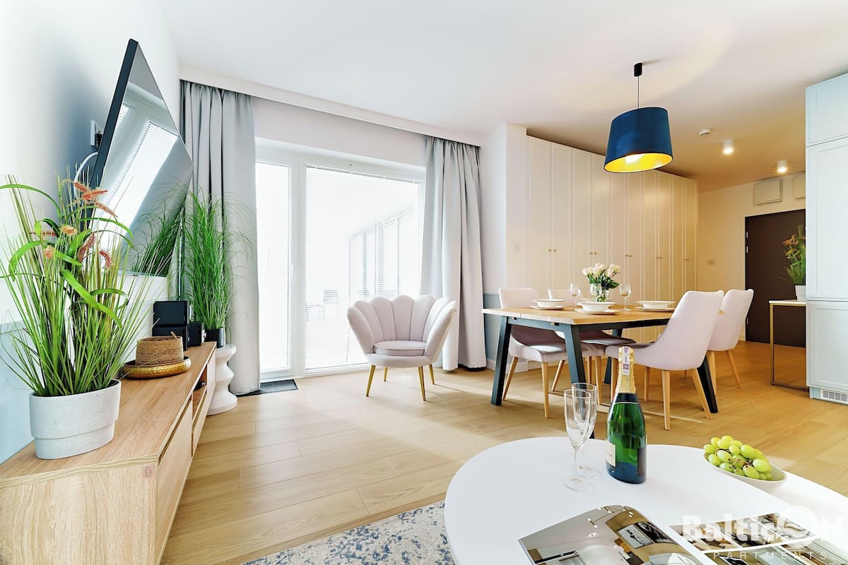 Un soggiorno moderno con zona pranzo, ampie finestre e vista sulla città.