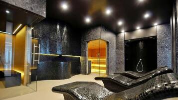 A spa area with a massage chair, a glass-enclosed shower, and a dark-toned wall with a textured finish.