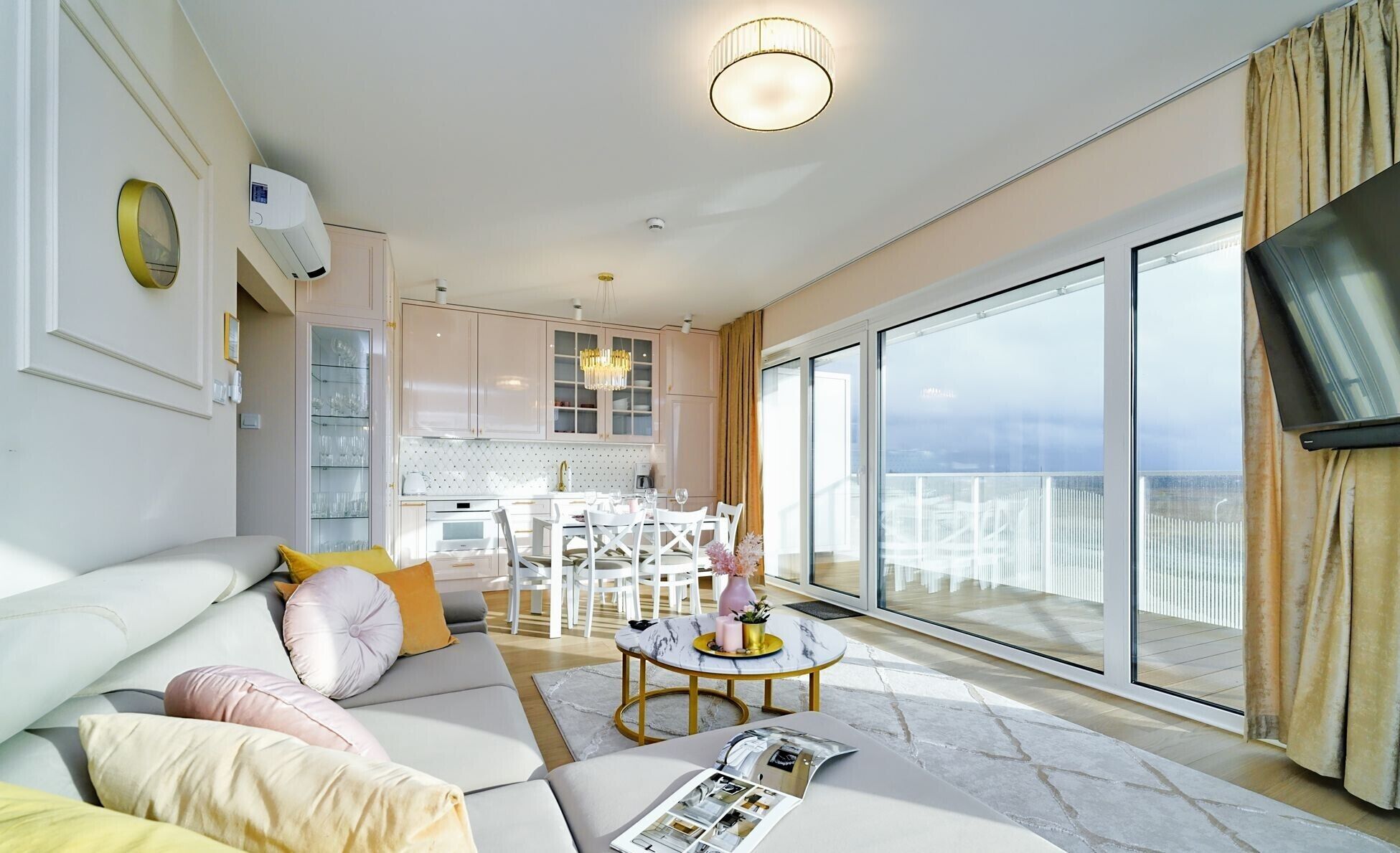 A modern living room with a sofa, coffee table, and a dining area.