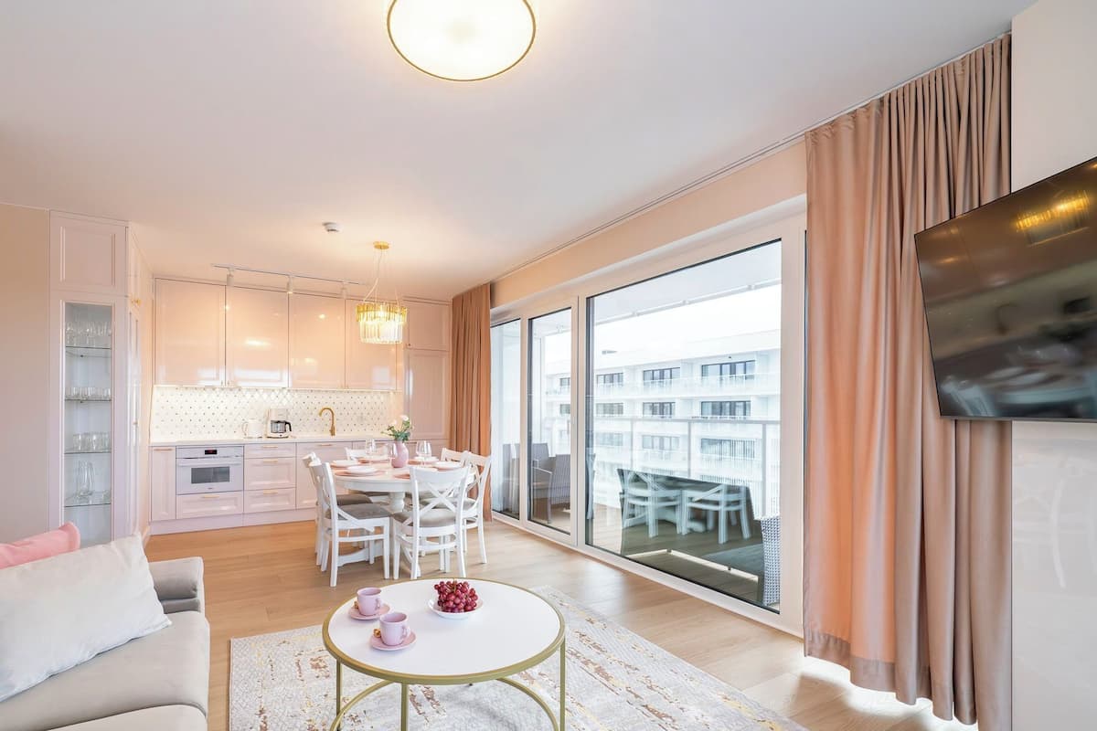 Un appartamento moderno con zona pranzo, cucina e un ampio balcone vista città.