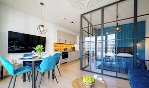 Una sala de estar moderna con comedor, cocina y un gran ventanal que ofrece vistas de la ciudad.