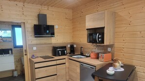 Una cocina compacta con muebles de madera, un microondas, una cafetera y un tostador.