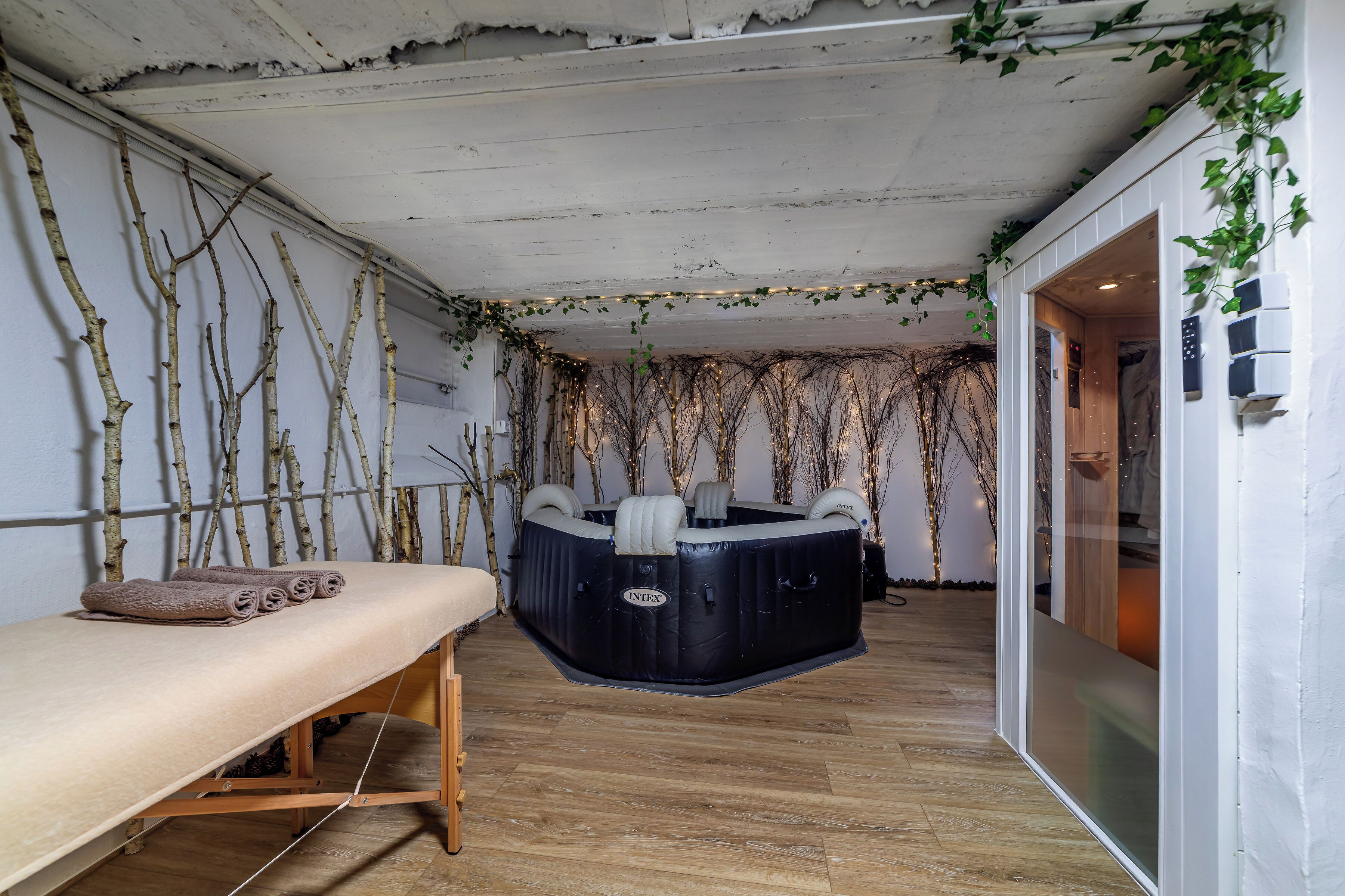 Un cuarto de spa con un banco de madera, una camilla de masaje y un jacuzzi.