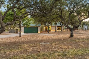 A residential property with a garage, a small building with a door, and a fenced yard. - Tawnya’s Secret Hideaway | 20-Mile Views (Dripping Springs)