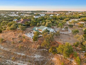 A residential area with a house featuring a patio and a fenced yard. - Tawnya’s Secret Hideaway | 20-Mile Views (Dripping Springs)