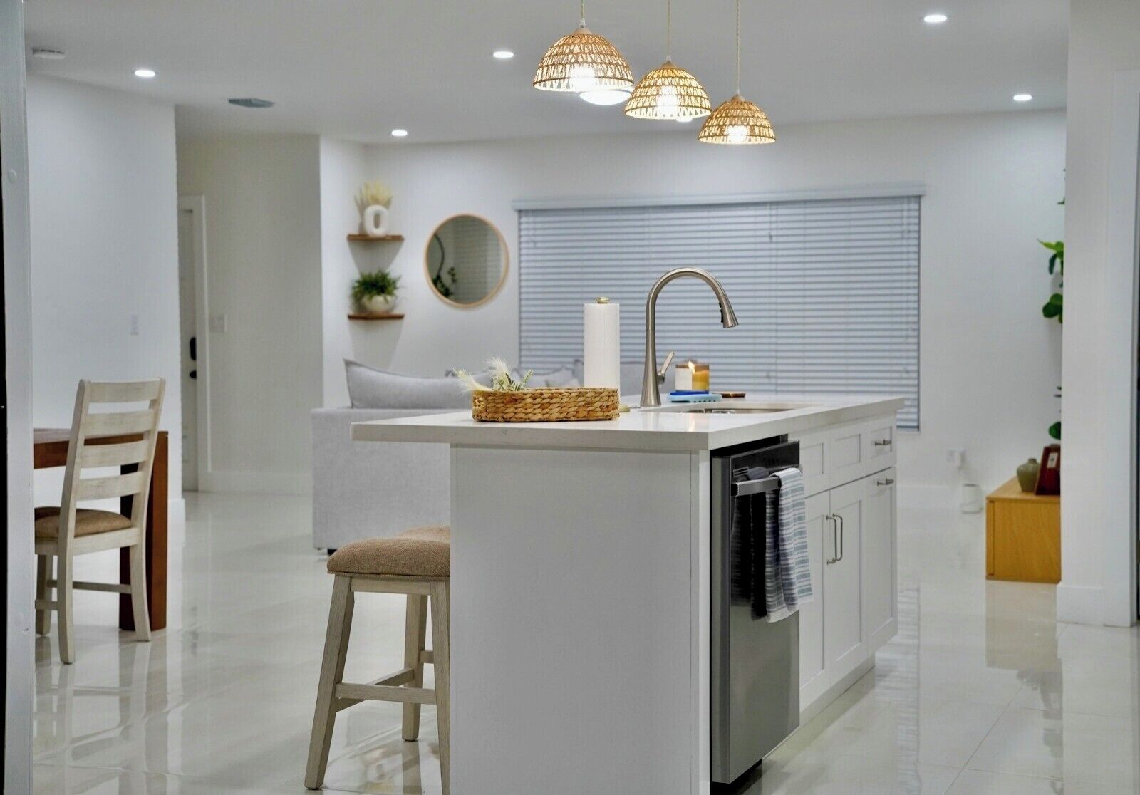 Une cuisine moderne dotée d’un îlot central, d’appareils électroménagers intégrés et de luminaires suspendus.