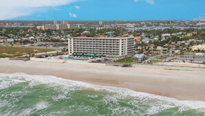 A large hotel with multiple floors and a parking lot in front. - Wonderful Apartment on the Beach (Daytona Beach)