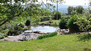 A garden with a pond, outdoor seating, and a view of the countryside. - An eco-renovated house full of charm, a garden and a magnificent view. (Varen)
