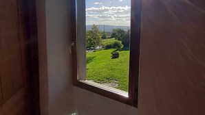 A room with a window overlooking a green landscape. - An eco-renovated house full of charm, a garden and a magnificent view. (Varen)
