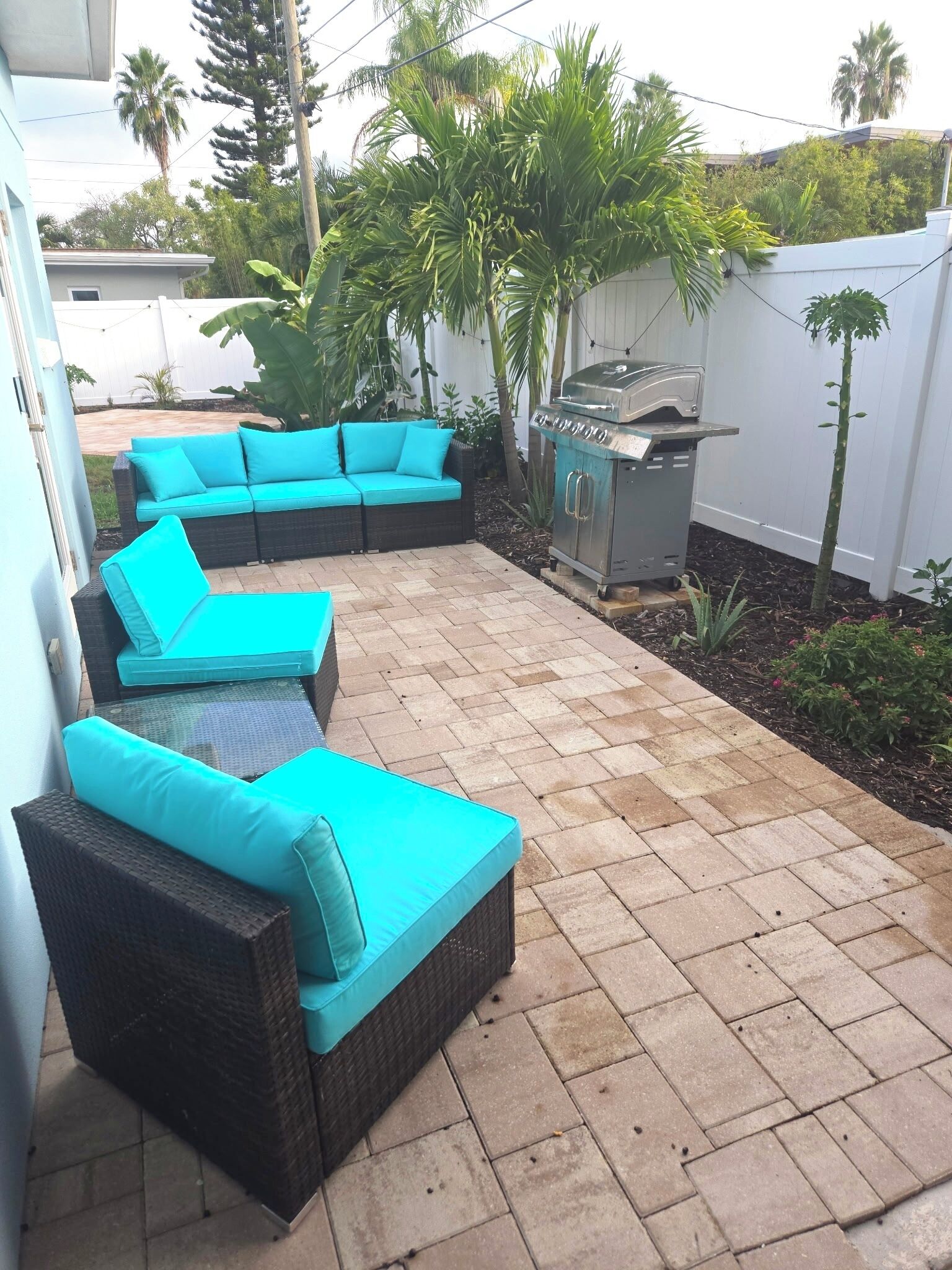 Eine Terrasse mit Ecksofa und Grill.