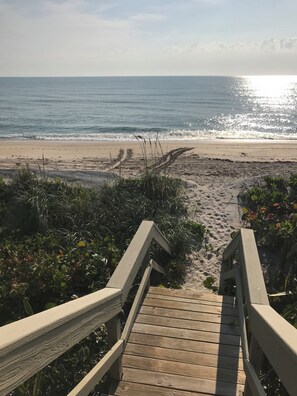 A wooden boardwalk leading to a beach with a sandy path and vegetation. - Fabulous 6-bedroom ocean front house in Melbourne Beach (Melbourne Beach)