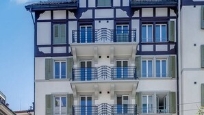 Un edificio a più piani con architettura tradizionale, caratterizzato da balconi con ringhiere in metallo e diversi tipi di finestre.