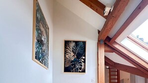 A bright yellow armchair in a spacious room with wooden floors and exposed beams. - Cozy 2.5 room apartment in Winterthur (Winterthur)
