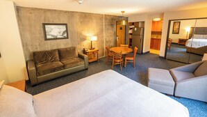 A hotel room with a large bed, a sofa, a dining table with chairs, a small kitchen area, and a mirror. - Ski-in/ski-out unit 1027 for 4 people @Snowbird for New Year's week, 12/27-1/3 (Snowbird)